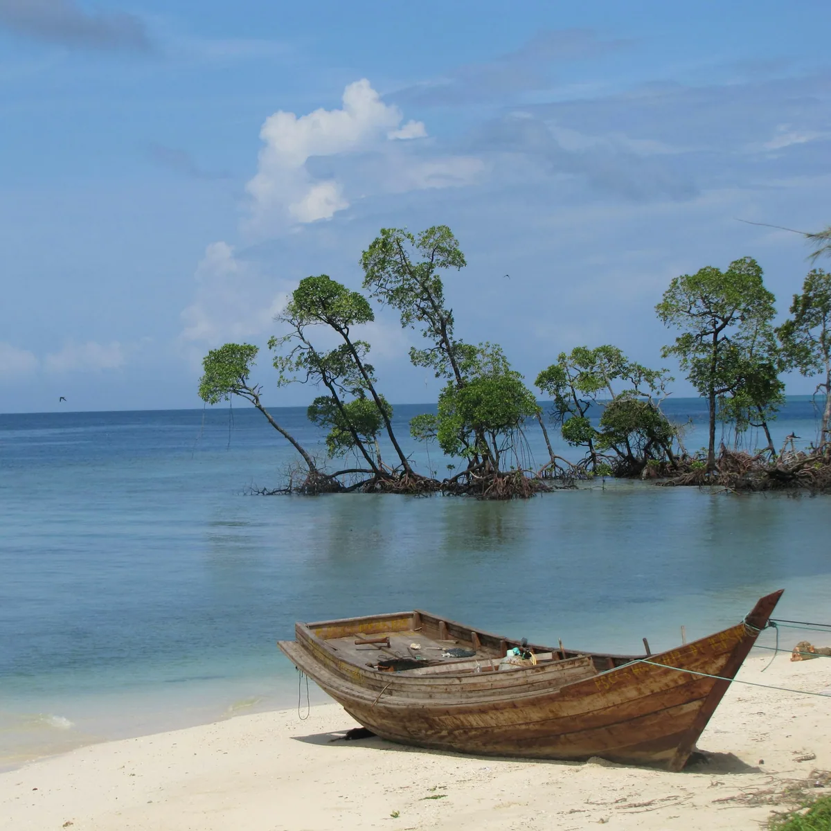 Brown wooden jon boat on seashore, Andaman