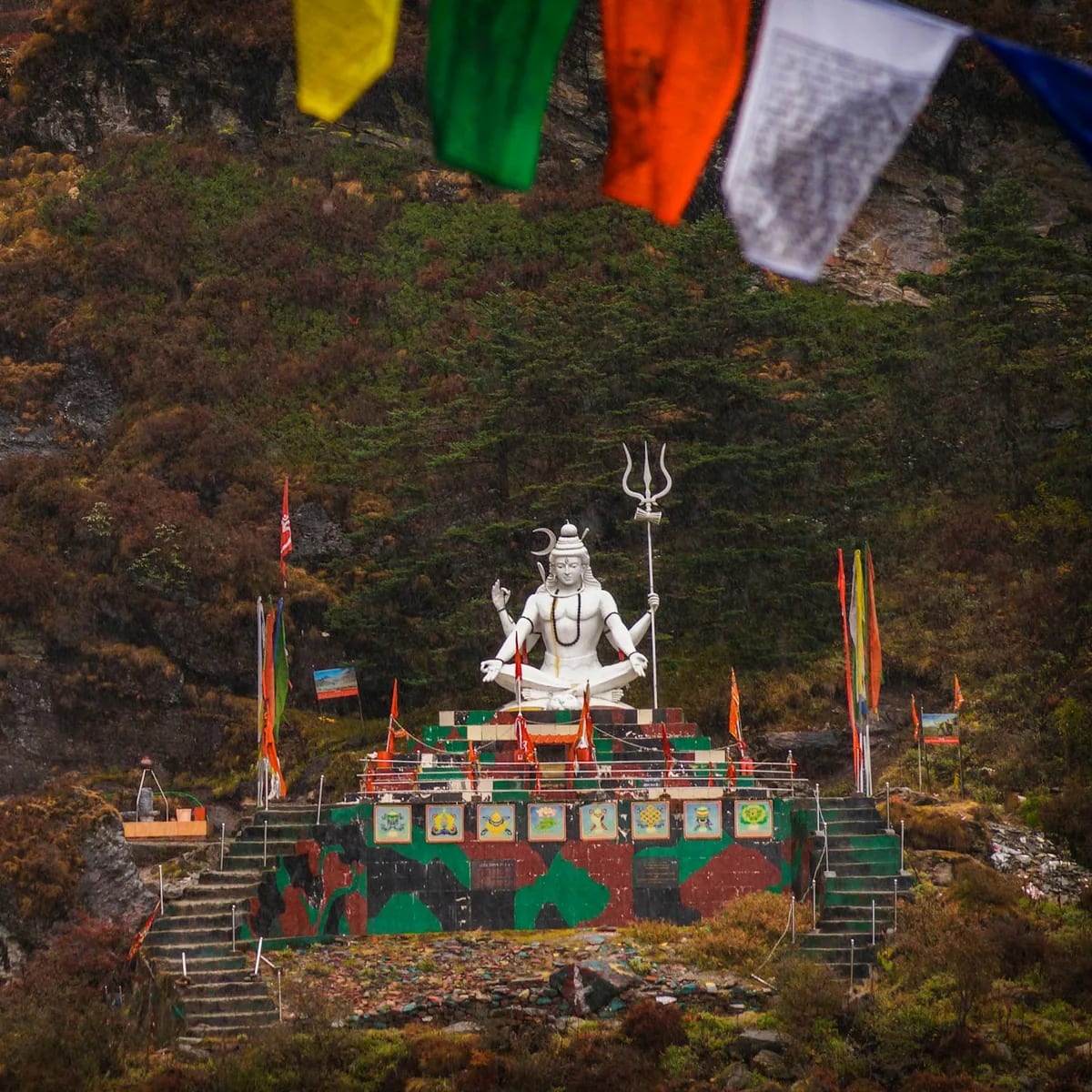 A large white statue sitting in front of a waterfall, Dharamshala