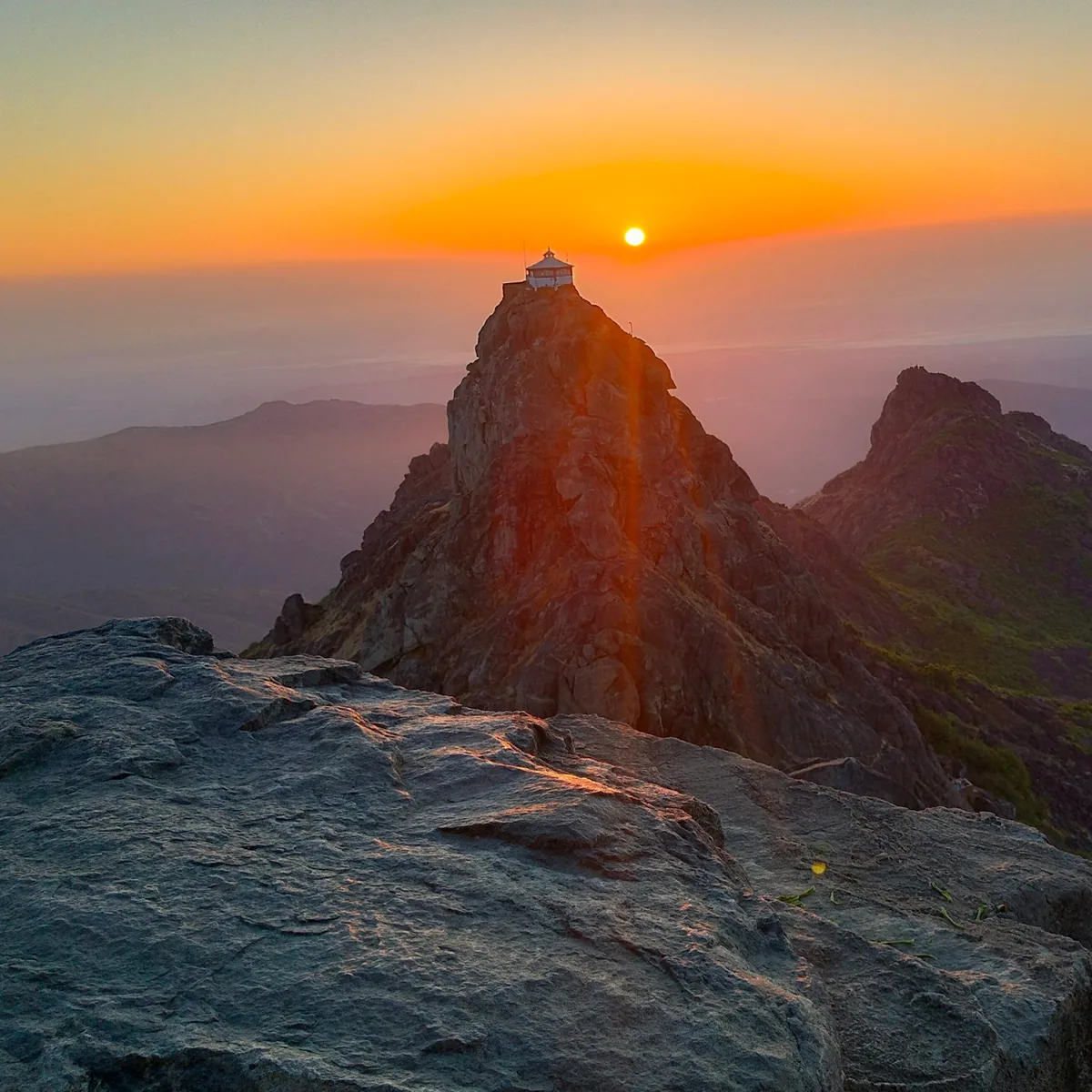 The sun is setting over a mountain peak, Gujarat