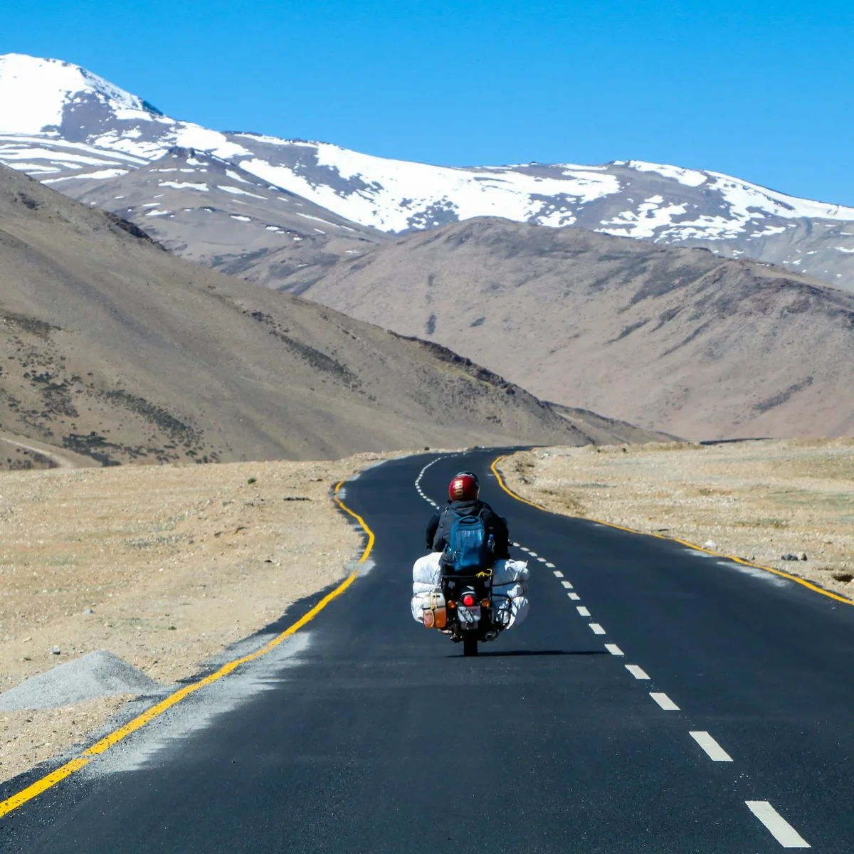 Man riding motorcycle on road during daytime, Ladakh