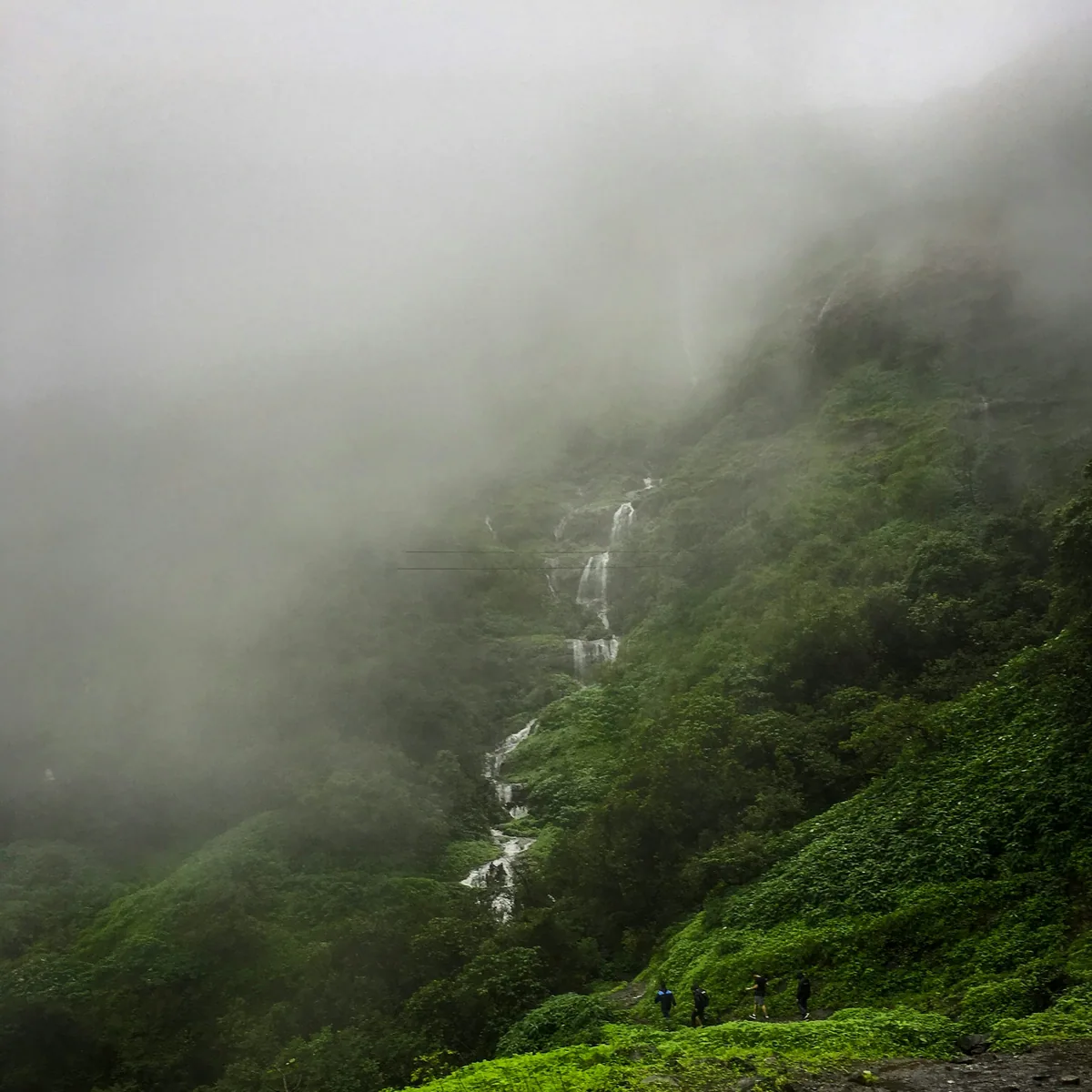 A group of people walking on a path in a foggy mountain, Lonavala